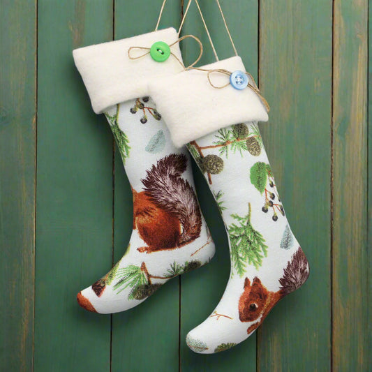 Pair of Christmas stockings with woodland animals on a light blue background