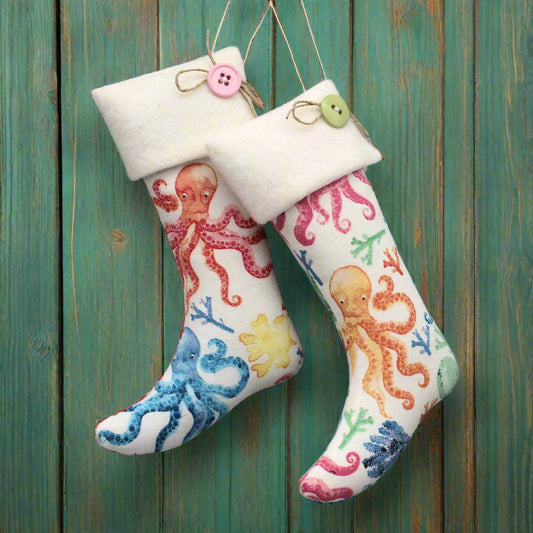 Christmas stocking ornaments with colorful octopi on a white background and white cuffs decorated with buttons