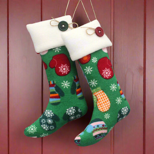 Christmas stocking ornaments with colorful mittens on a green background with white cuffs decorated with buttons