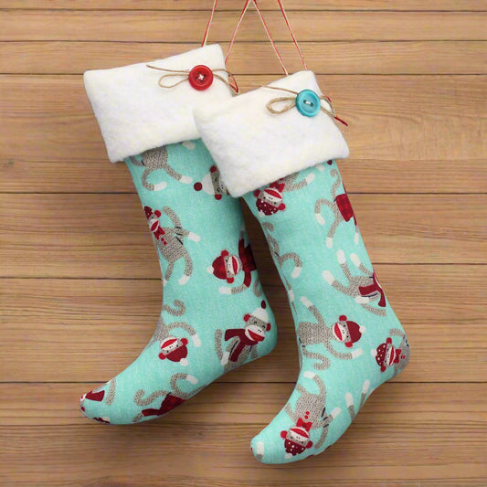 Pair of turquoise Christmas stockings with white cuffs and red buttons
