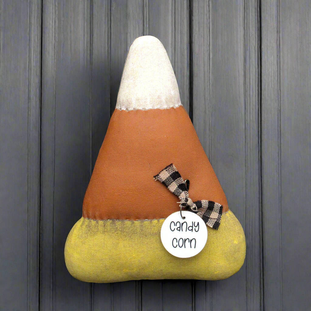 Distressed candy corn bowl filler with a tag on a wooden background