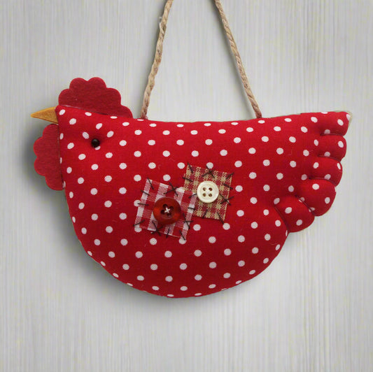 Red polka dot fabric chicken ornament with a button on a white background