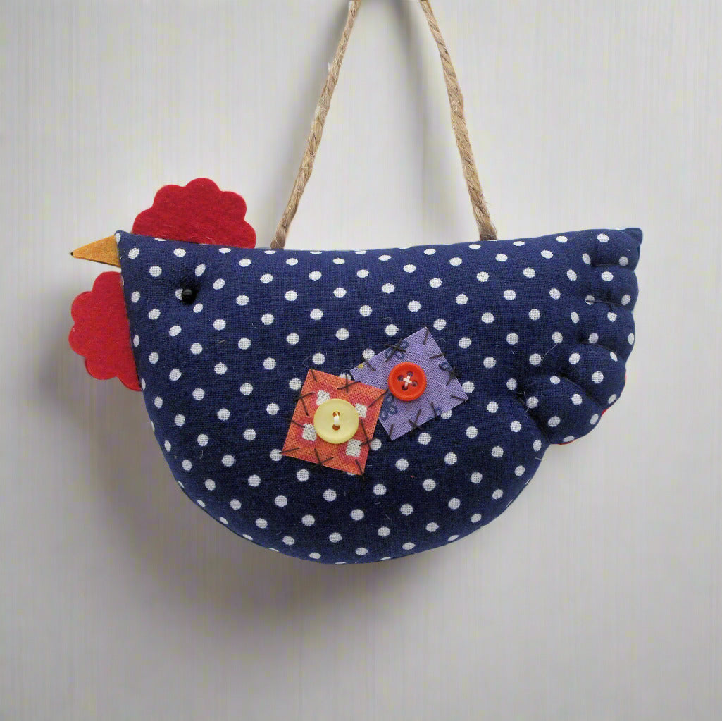 Decorative hanging chicken with blue polka dot body and colorful accents on a white background