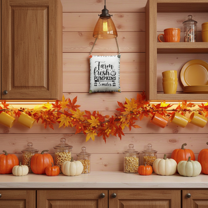 Decorative fall scene in a kitchen with pumpkins, jars, and a sign.