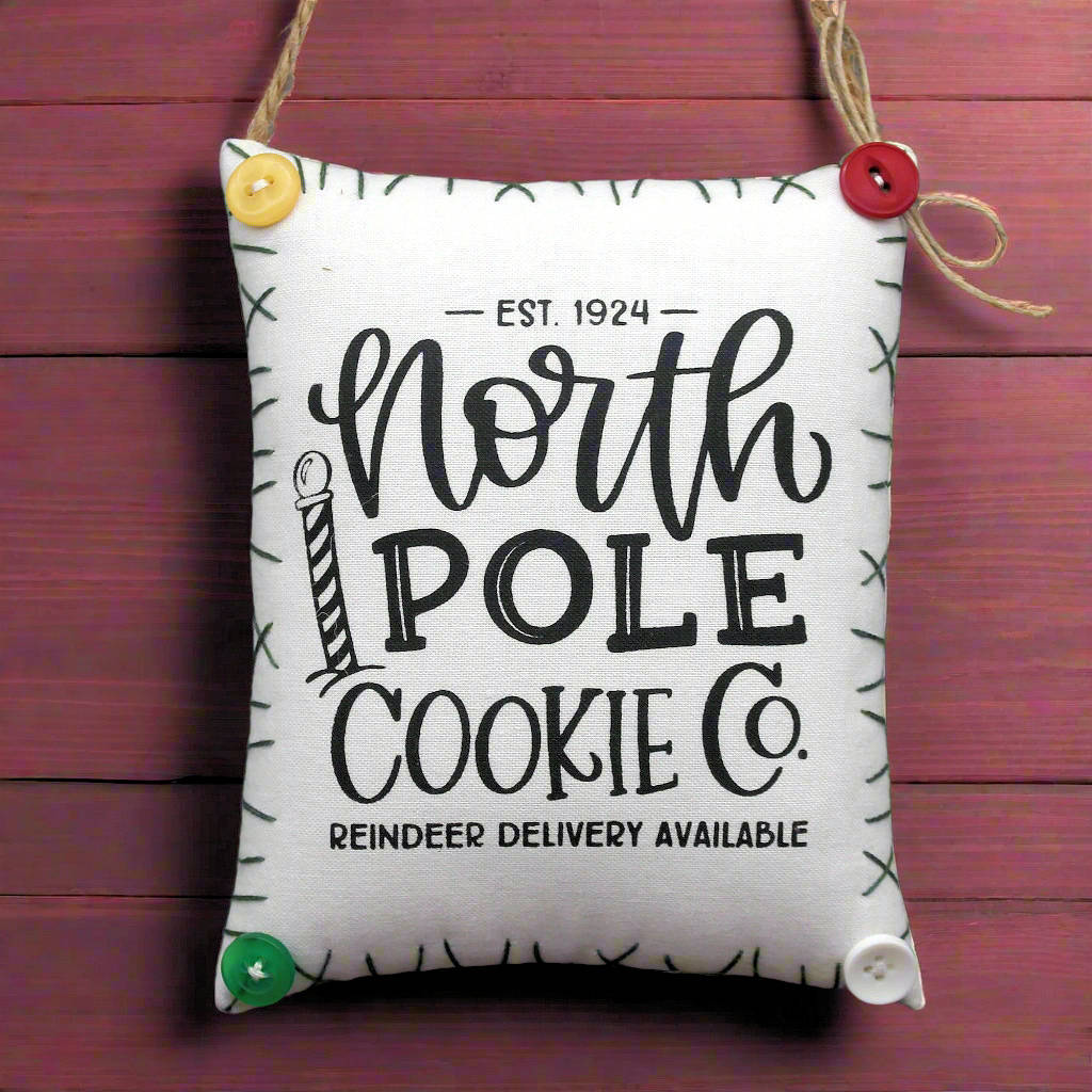 Fabric bag with 'North Pole Cookie Co.' text on a wooden background
