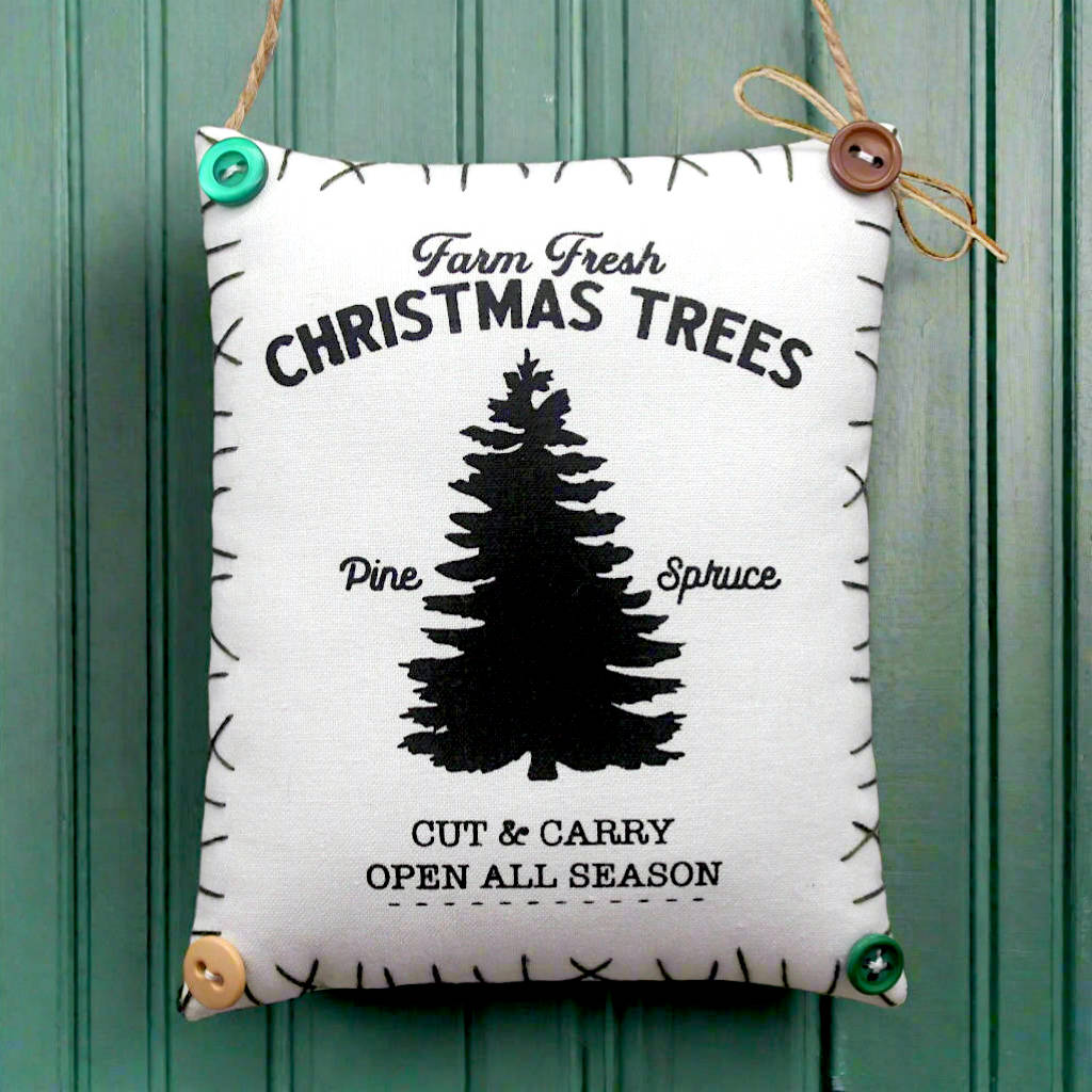 Decorative sign with Christmas tree design and text on a green wooden background