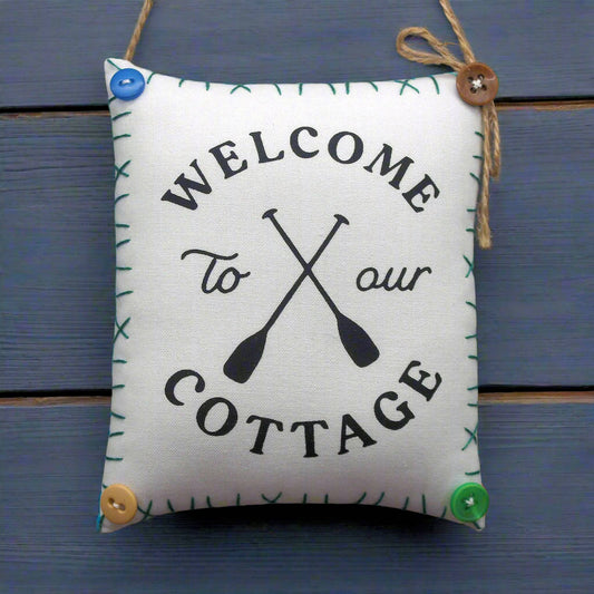 hanging mini pillow that reads welcome to our cottage