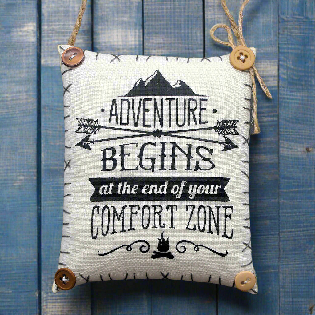 hanging mini pillow that reads Adventure Begins at the End of Your Comfort Zone