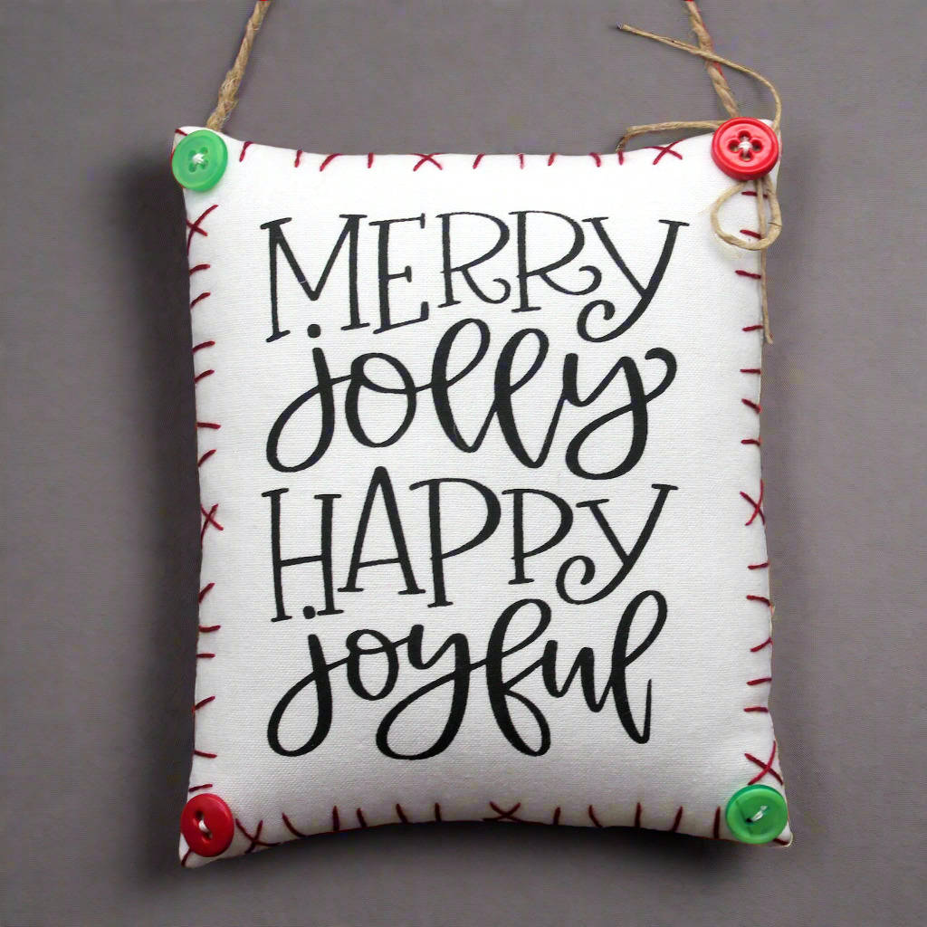 Decorative sign with 'Merry Jolly Happy Joyful' text on a plain background