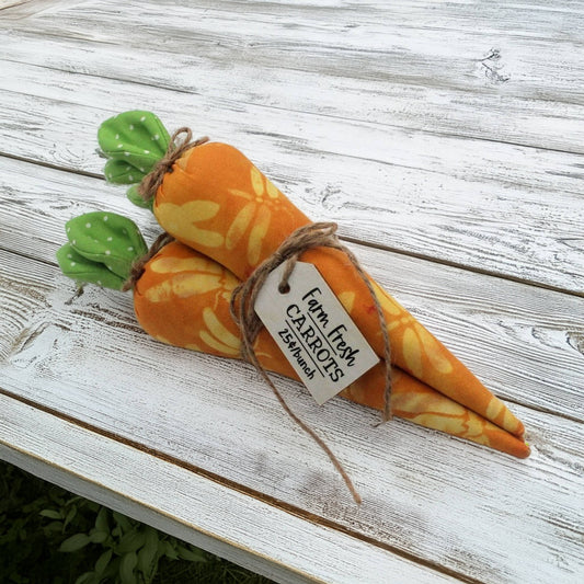 Three fabric carrots tied in a bundle on a wooden table