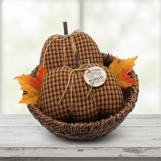 Decorative homespun fabric pumpkins in a basket on a wooden shelf