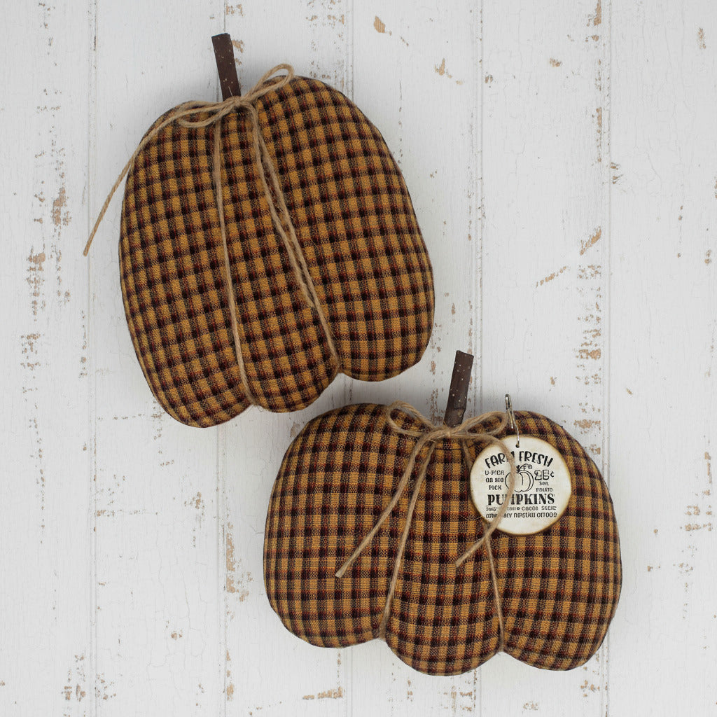 Two homespun fabric pumpkins with a tag on a white background
