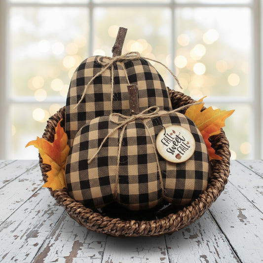 Decorative gourds with checkered pattern and 'Autumn Harvest' tag in a woven basket on a wooden surface.
