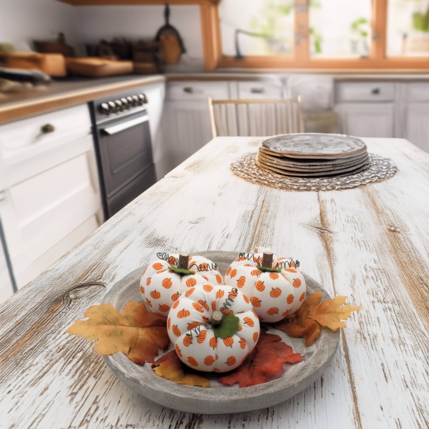 Decorative fabric pumpkins with orange patterns on a wooden table in a kitchen.