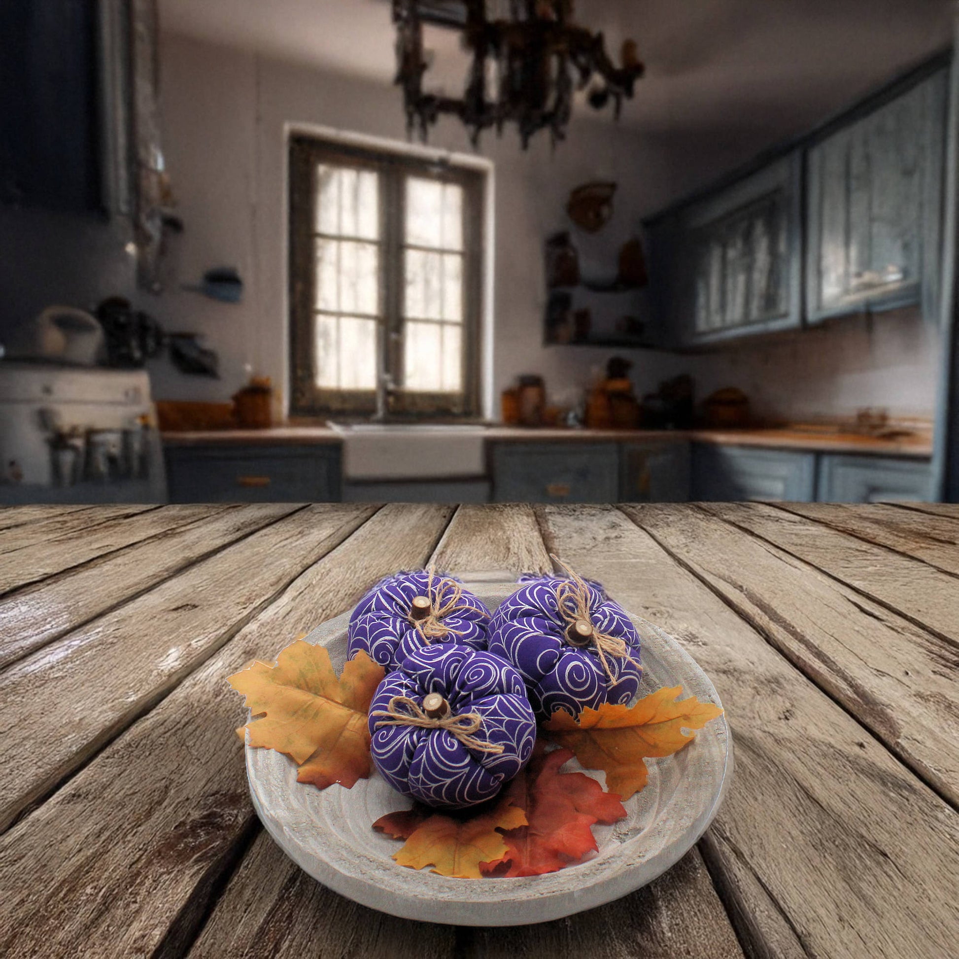 Decorative purple pumpkins with spider webs on a plate with autumn leaves in a haunted house kitchen setting.