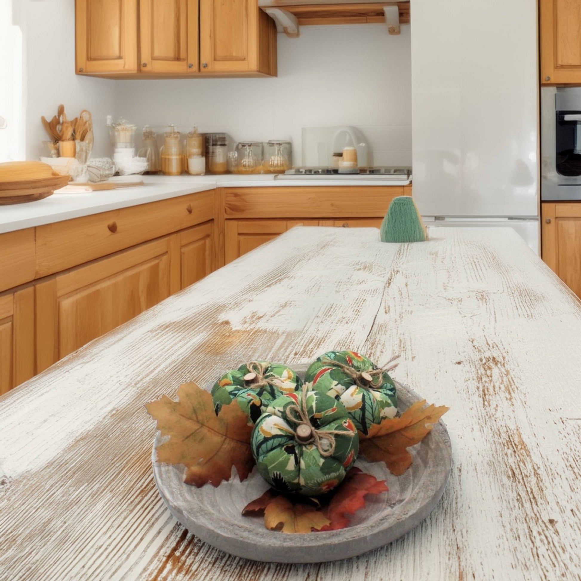 Decorative green pumpkins with leaves on a wooden surface in a kitchen.