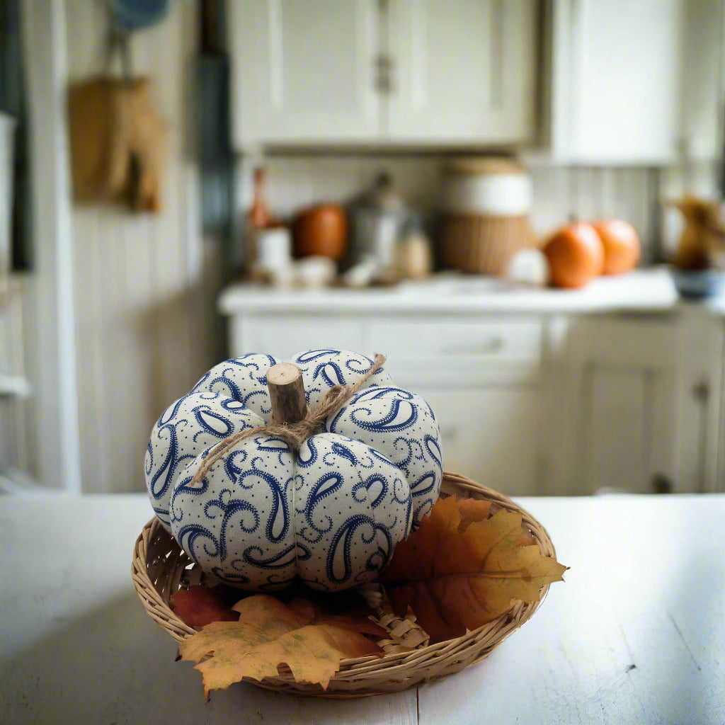 Decorative pumpkin with blue patterns in a woven basket