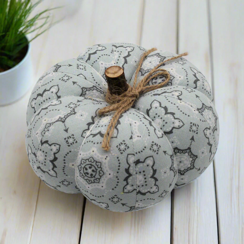 Decorative pumpkin with a bandana pattern on a white wooden surface