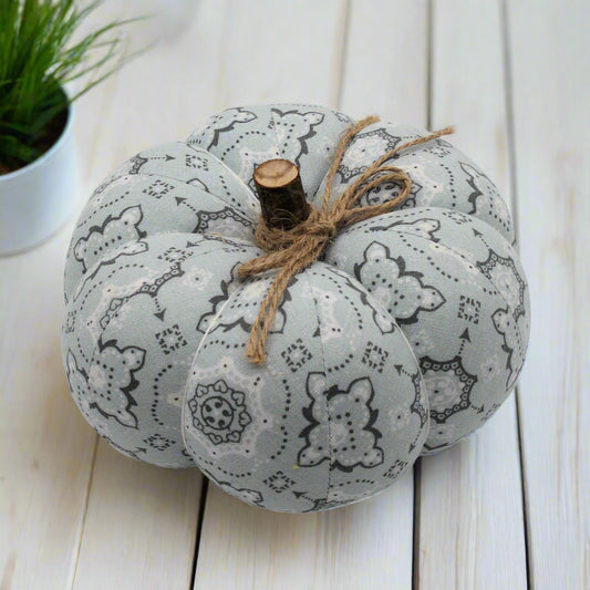 Decorative pumpkin with a bandana pattern on a white wooden surface