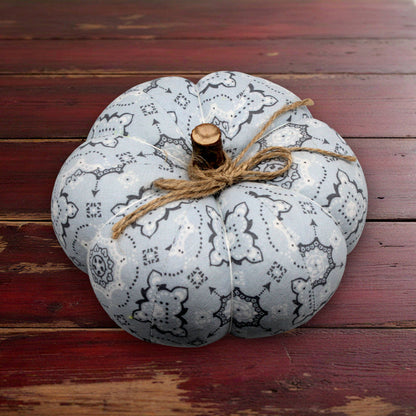 Decorative pumpkin with a light blue bandana pattern on a wooden surface