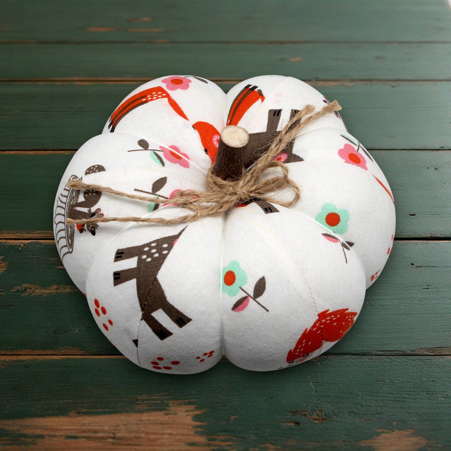 Decorative fabric pumpkin with a floral pattern on a wooden surface