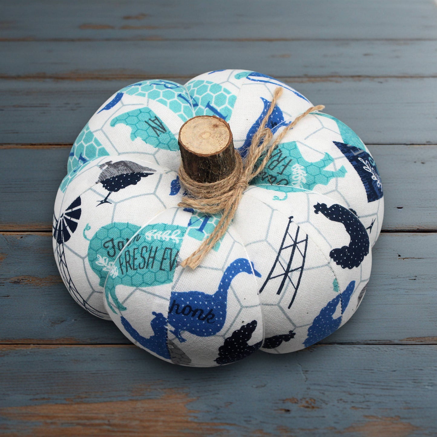 Decorative fabric pumpkin with blue and white pattern on a wooden surface
