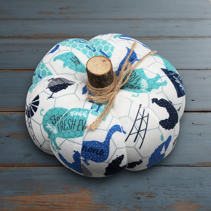 Decorative fabric pumpkin with blue and white pattern on a wooden surface