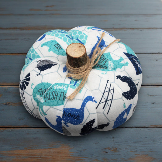 Decorative fabric pumpkin with blue and white pattern on a wooden surface