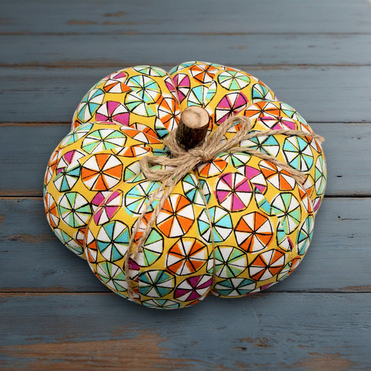 Decorative pumpkin with a colorful geometric pattern on a wooden surface