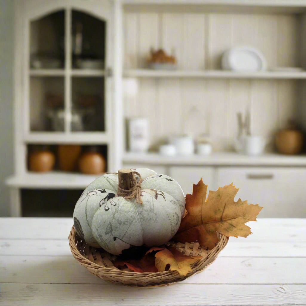 Decorative pumpkin with leaves in a basket on a kitchen counter