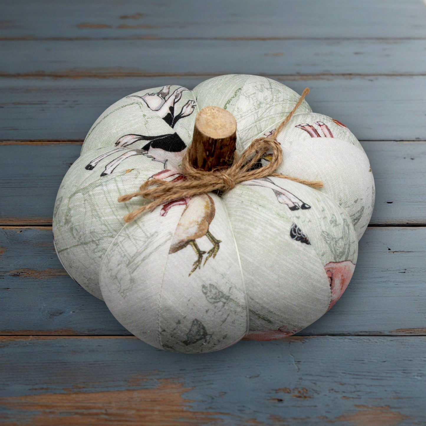 Decorative pumpkin with farmhouse print designs on a wooden surface