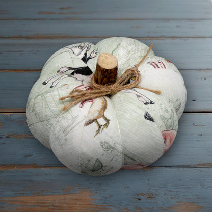 Decorative pumpkin with farmhouse print designs on a wooden surface