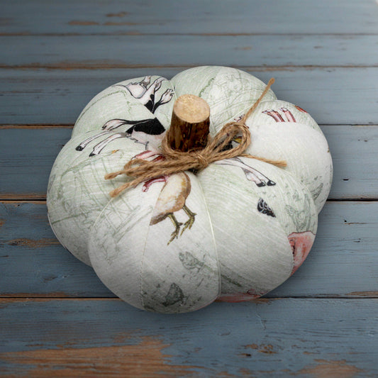 Decorative pumpkin with farmhouse print designs on a wooden surface