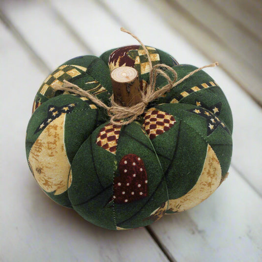 Quilted pumpkin decoration with patchwork pattern on a white surface