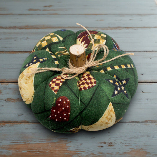 Decorative green fabric pumpkin on a wooden surface