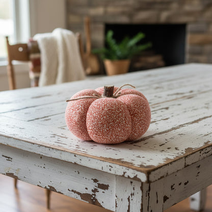 Decorative fabric pumpkin with an orange swirl design on a white background