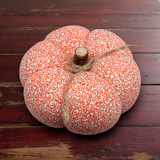 Decorative pumpkin with orange swirl pattern on a wooden surface