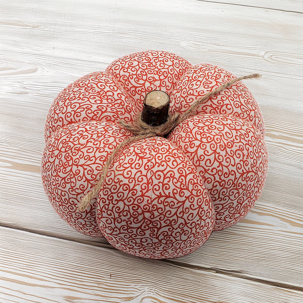 Decorative pumpkin with orange swirl pattern on a wooden surface
