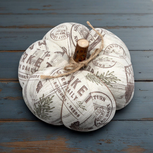Decorative pumpkin with vintage-style text and graphics on a wooden surface
