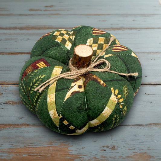 Decorative fabric pumpkin with a wooden stem on a white wooden surface