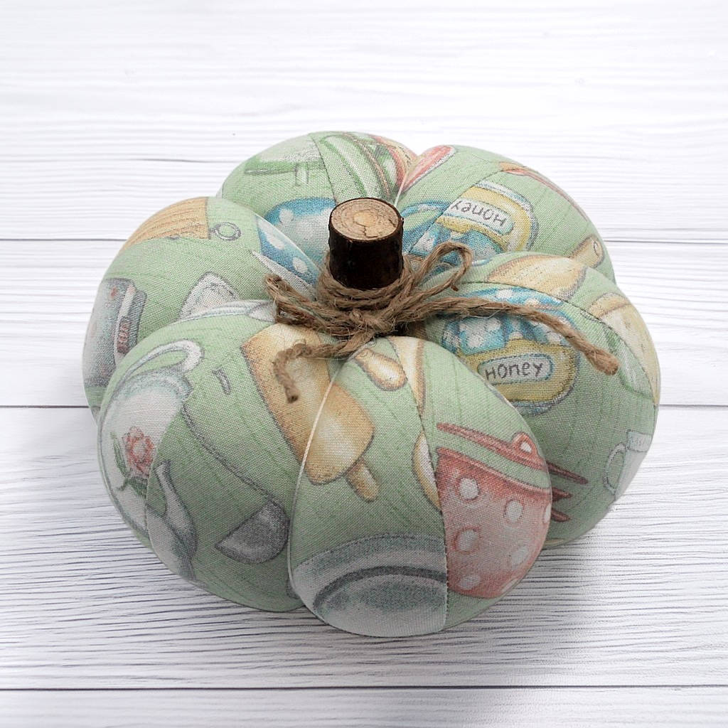 Decorative fabric pumpkin with a rustic appearance on a white wooden surface