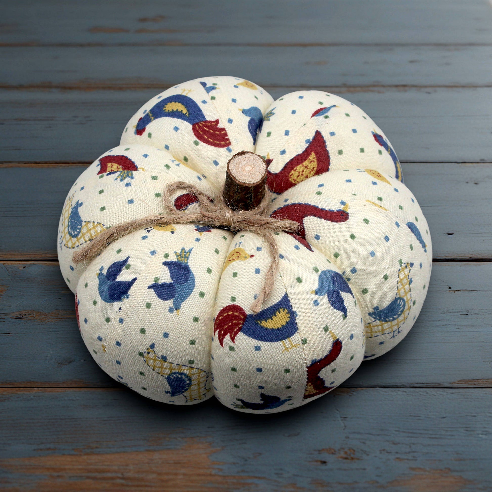 Decorative pumpkin with bird pattern on a wooden surface