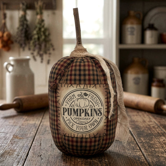 Decorative pumpkin with plaid pattern and 'Farm Fresh Pumpkins' label on a wooden surface.