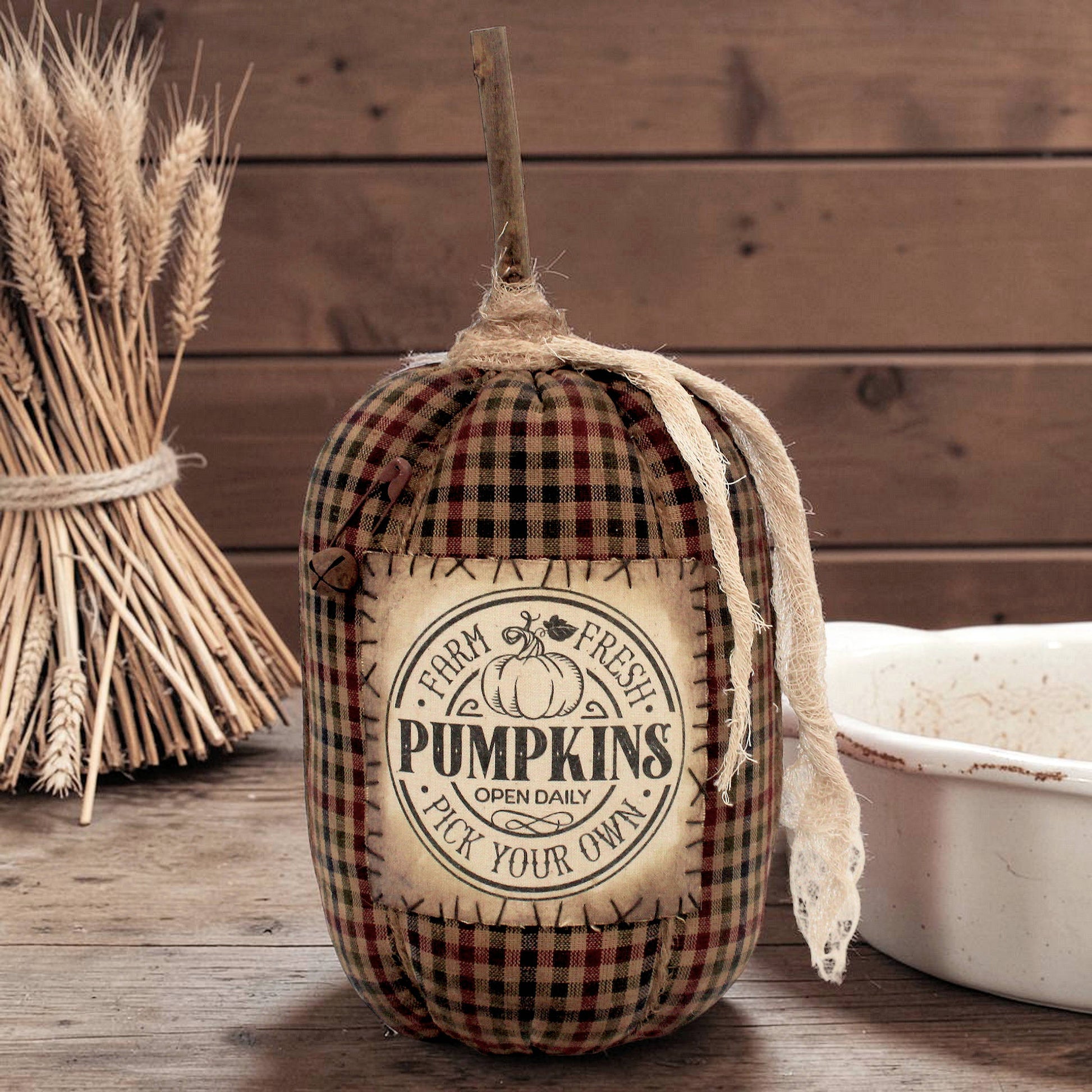 Decorative pumpkin with plaid pattern and 'Farm Fresh Pumpkins' label on a wooden background