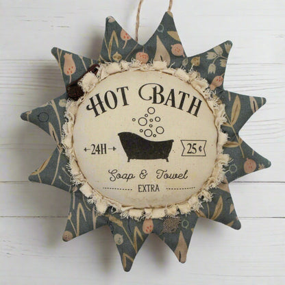 Primitive fabric sunflower ornament with an advertisement for a hot bath
