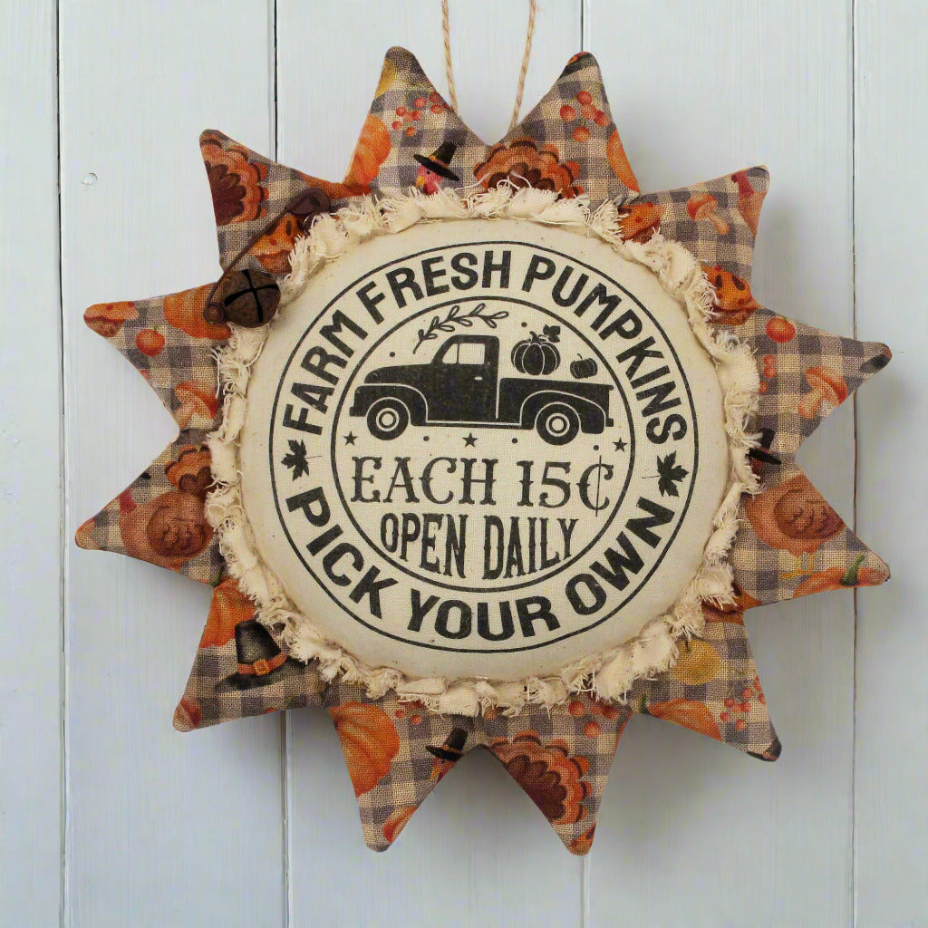 Primitive fabric sunflower ornament with an advertisement for farm fresh pumpkins