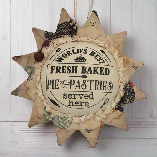 Primitive sunflower ornament with an advertisement for pies and pastries