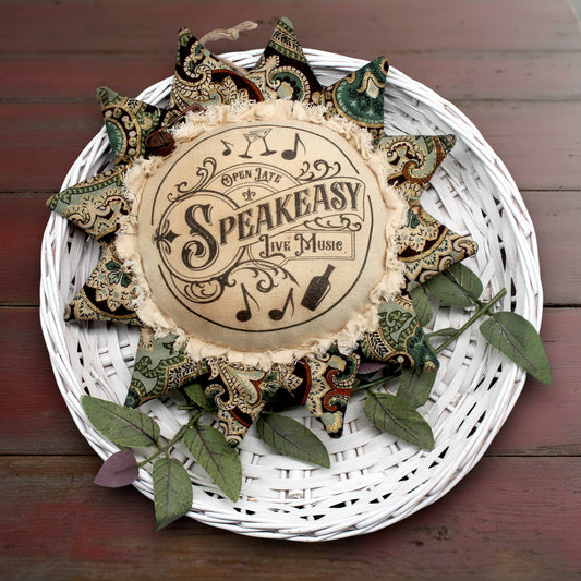 Decorative sunflower ornament with 'Speakeasy' text on a white woven plate with decorative elements.
