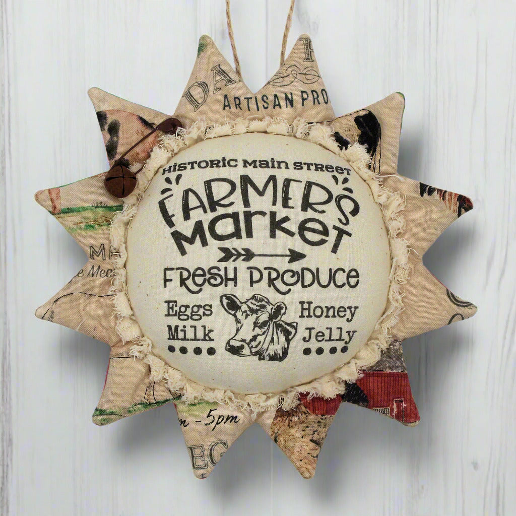 Primitive fabric sunflower ornament with an advertisement for a farmers market