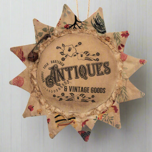 Decorative primitive sunflower ornament with 'Antiques & Vintage Goods' text